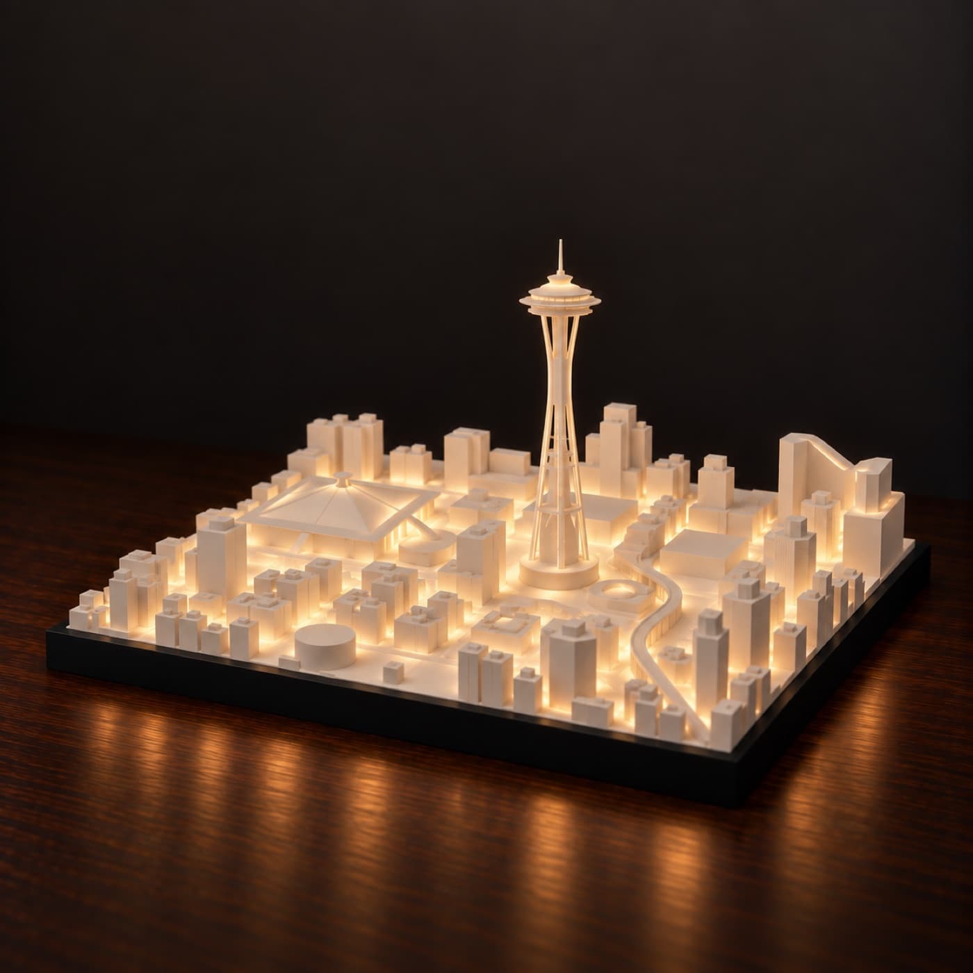 Seattle Skyline Lamp, lit, on a dark wood table